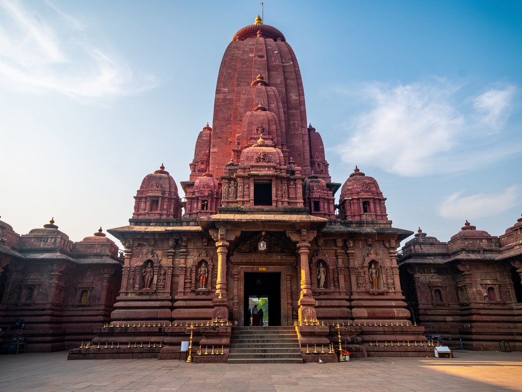 The deep-red shikhara of Mahalaxmi Temple Kolhapur against a clear sky